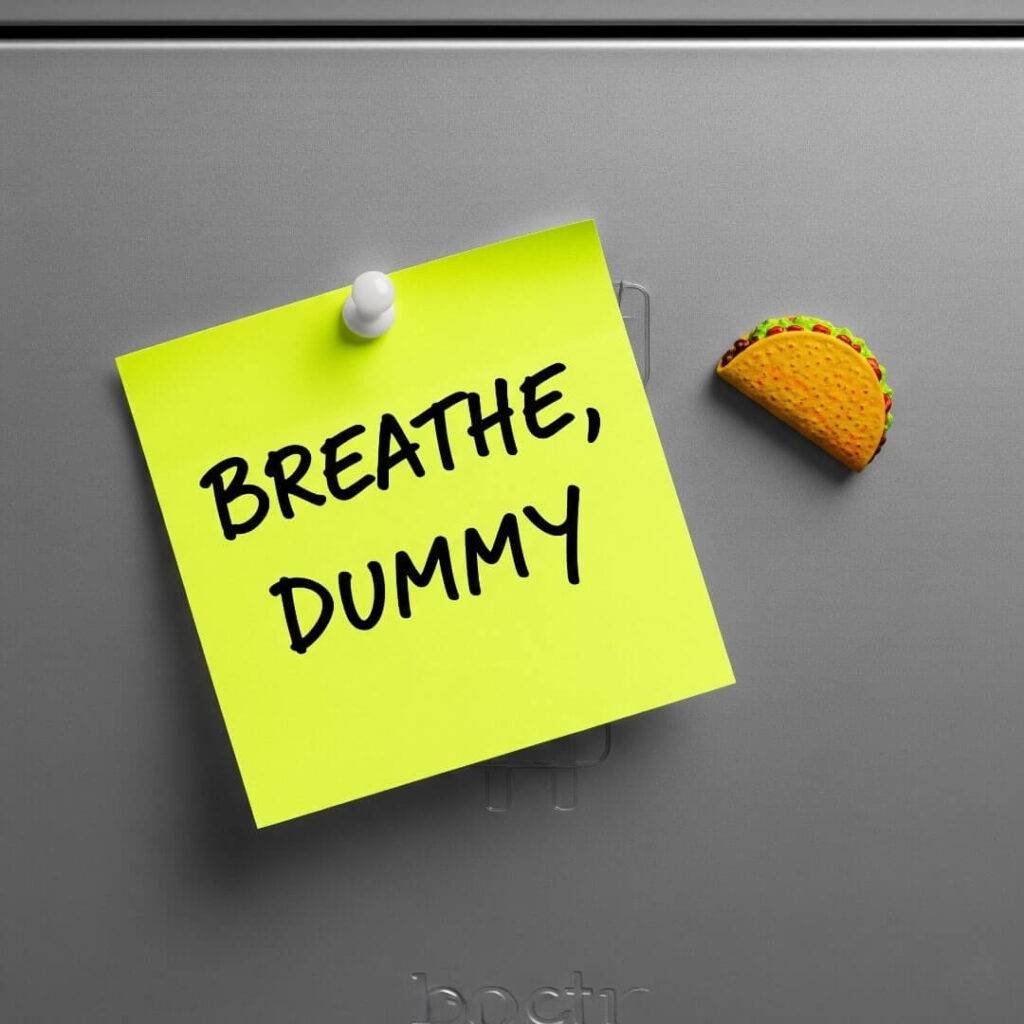 A high-resolution flat-lay of a neon yellow sticky note with "Breathe, Dummy