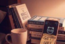 How to Build a Morning Routine You’ll Actually Stick to A close-up of a messy nightstand with an alarm clock