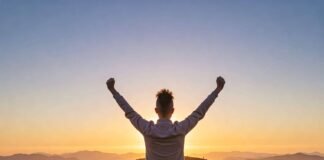 Growth Mindset Activities to Boost Your Confidence Triumphant figure on hill at sunrise.