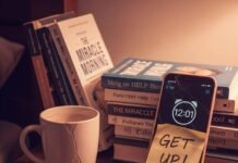 How to Build a Morning Routine You’ll Actually Stick to A close-up of a messy nightstand with an alarm clock