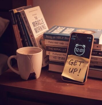 How to Build a Morning Routine You’ll Actually Stick to A close-up of a messy nightstand with an alarm clock